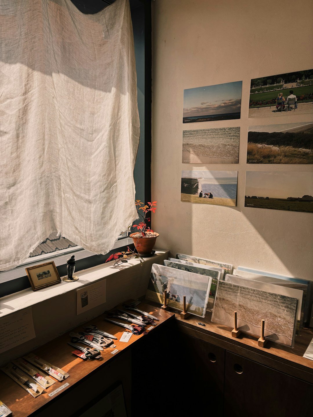 Photo archive desk with printed photographs, negatives and a laptop